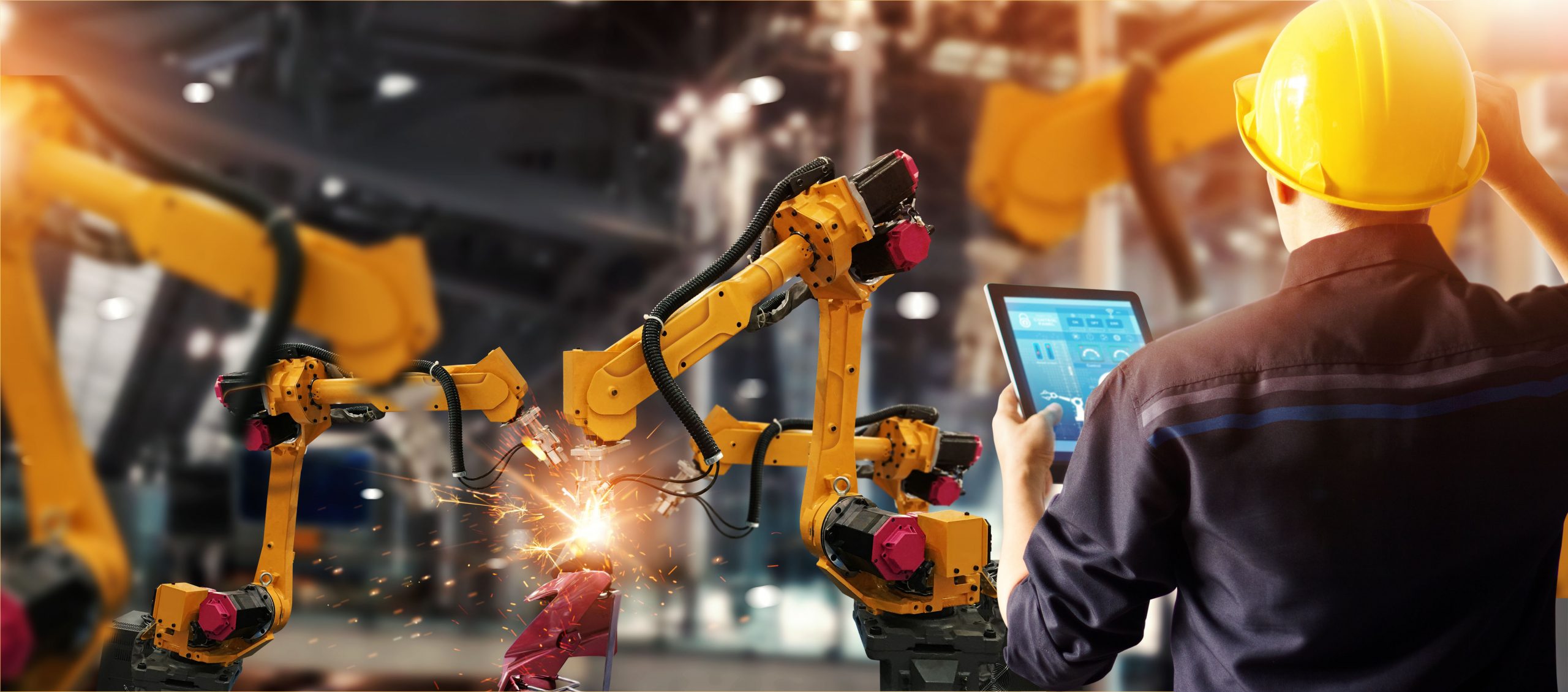 Een man bestuurt productierobots met een tablet