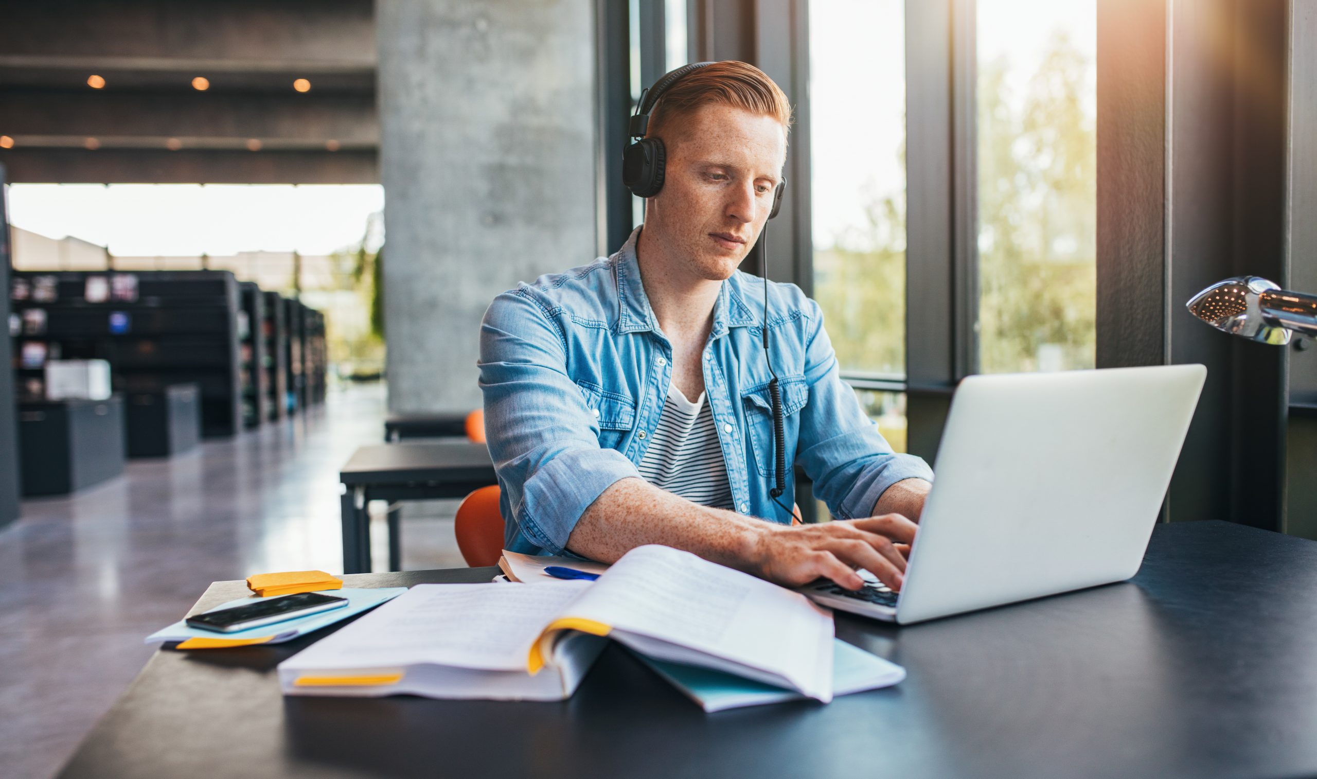 Axians sfeerbeeld, student aan het studeren in bibliotheek