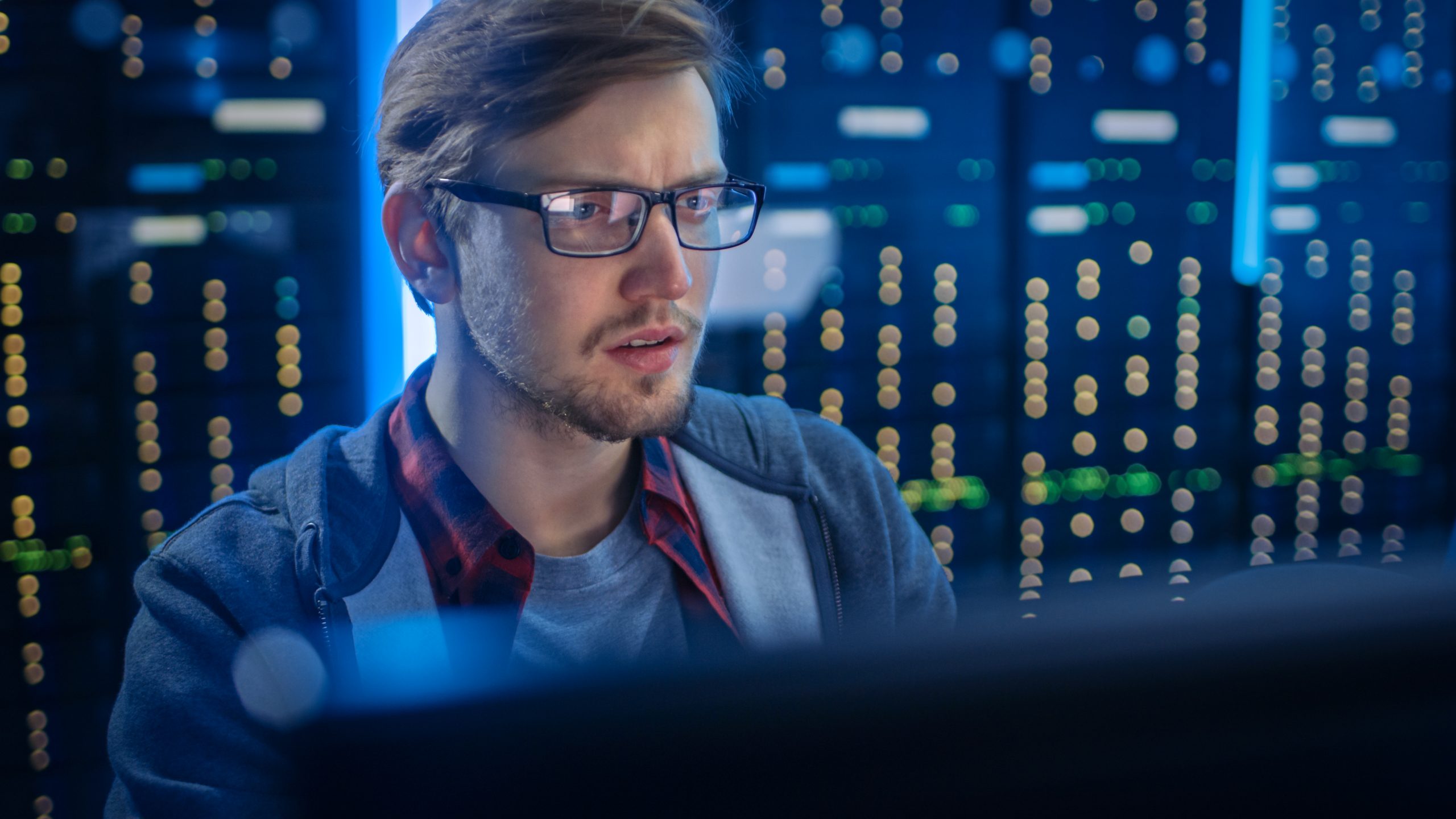 Axians sfeerbeeld, man werkt achter computer in datacenter